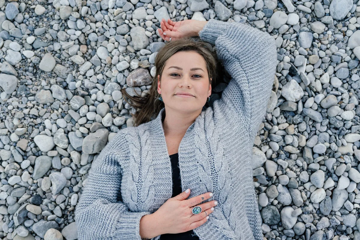 Jennifer Heng liegt auf grauen Kieseln und lächelt in die Kamera